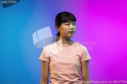 Image of Asian young woman\'s portrait on gradient studio background in neon