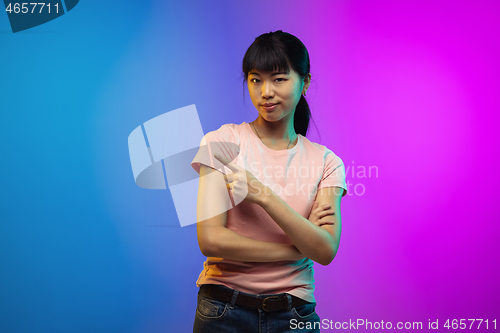 Image of Asian young woman\'s portrait on gradient studio background in neon