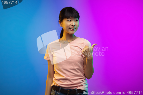 Image of Asian young woman\'s portrait on gradient studio background in neon