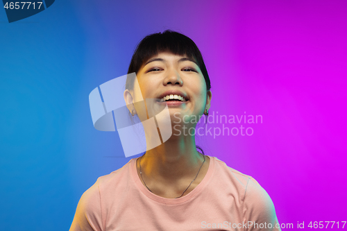 Image of Asian young woman\'s portrait on gradient studio background in neon