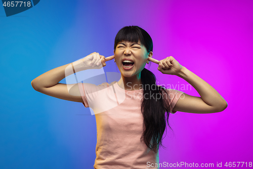 Image of Asian young woman\'s portrait on gradient studio background in neon