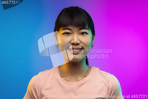 Image of Asian young woman\'s portrait on gradient studio background in neon