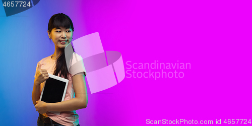 Image of Asian young woman\'s portrait on gradient studio background in neon