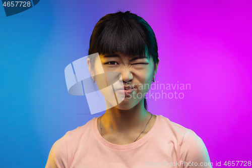 Image of Asian young woman\'s portrait on gradient studio background in neon