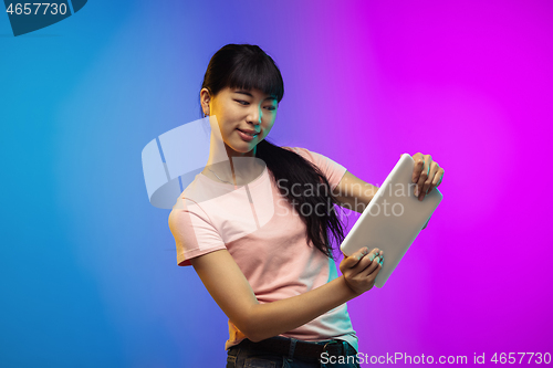 Image of Asian young woman\'s portrait on gradient studio background in neon