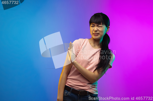 Image of Asian young woman\'s portrait on gradient studio background in neon