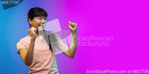 Image of Asian young woman\'s portrait on gradient studio background in neon