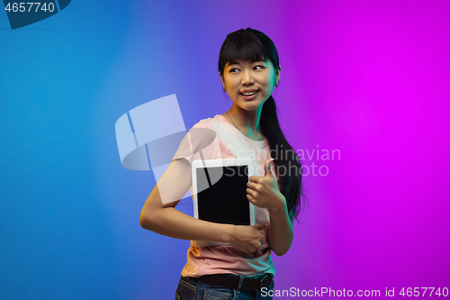 Image of Asian young woman\'s portrait on gradient studio background in neon