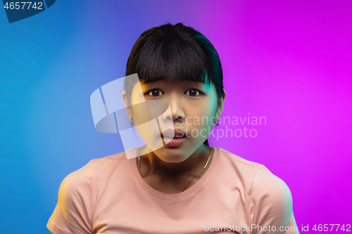 Image of Asian young woman\'s portrait on gradient studio background in neon