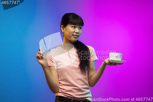 Image of Asian young woman\'s portrait on gradient studio background in neon