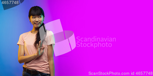 Image of Asian young woman\'s portrait on gradient studio background in neon