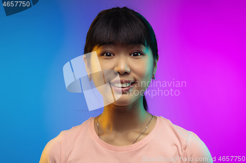 Image of Asian young woman\'s portrait on gradient studio background in neon