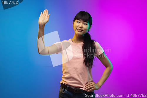 Image of Asian young woman\'s portrait on gradient studio background in neon