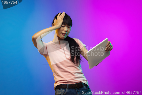 Image of Asian young woman\'s portrait on gradient studio background in neon