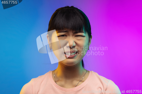 Image of Asian young woman\'s portrait on gradient studio background in neon