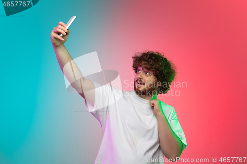 Image of Caucasian young man\'s portrait on gradient studio background in neon