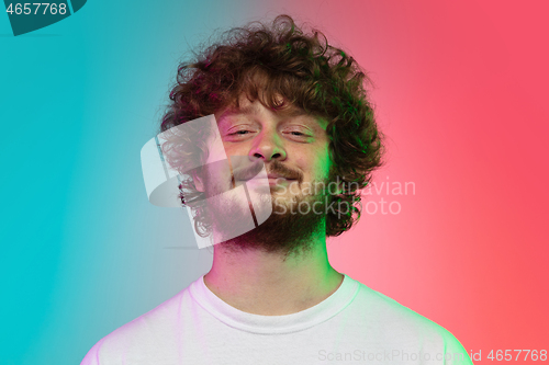 Image of Caucasian young man\'s portrait on gradient studio background in neon