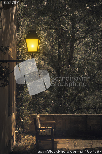 Image of lonely bench under a lamp by night