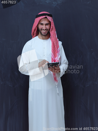 Image of young arabian muslim businessman using tablet computer