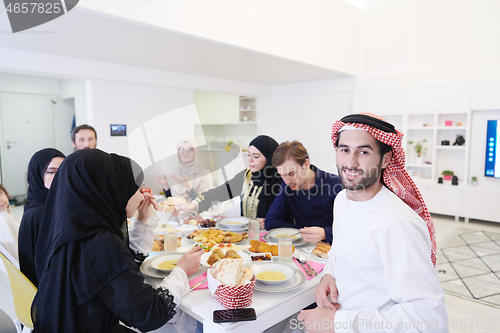 Image of young arabian man having Iftar dinner with muslim family