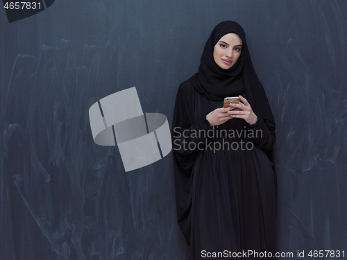 Image of young modern muslim business woman using smartphone