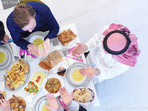 Image of traditional muslim family praying before iftar dinner