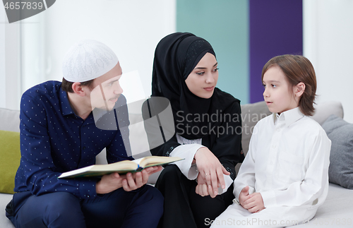 Image of muslim family reading Quran and praying at home