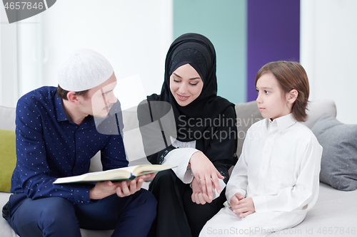 Image of muslim family reading Quran and praying at home