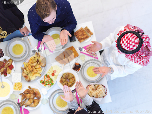 Image of traditional muslim family praying before iftar dinner