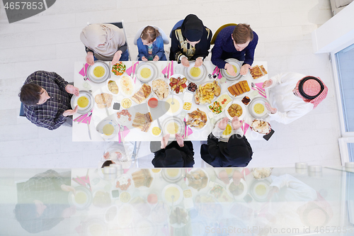 Image of traditional muslim family praying before iftar dinner top view