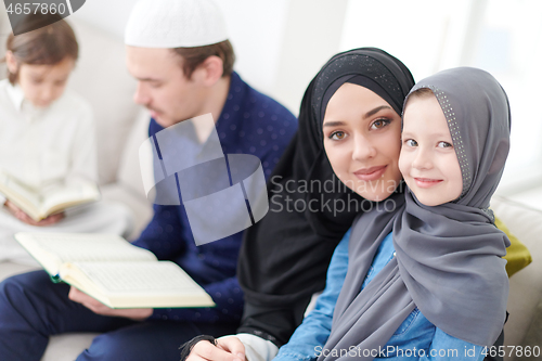 Image of muslim family reading Quran and praying at home