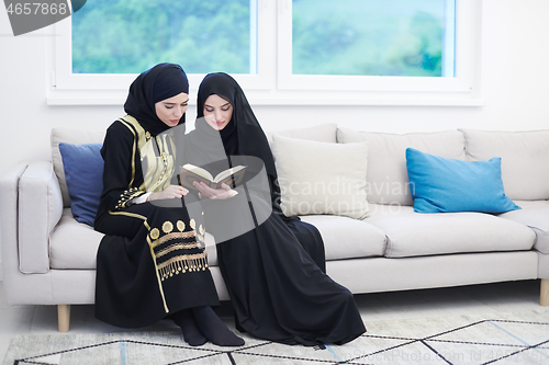 Image of young muslim women reading Quran at home