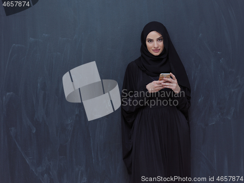 Image of young modern muslim business woman using smartphone