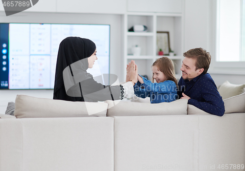 Image of Happy Muslim family having fun at home