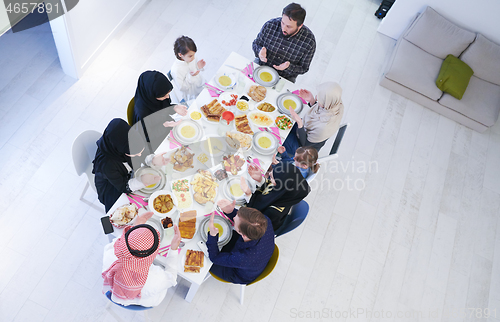 Image of traditional muslim family praying before iftar dinner