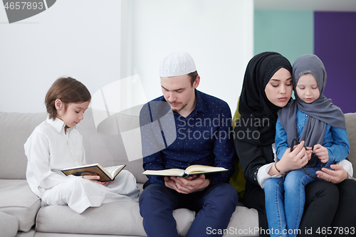 Image of muslim family reading Quran and praying at home