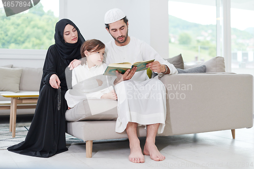 Image of muslim family reading Quran and praying at home