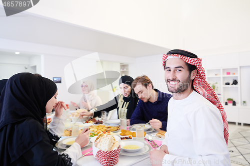 Image of young arabian man having Iftar dinner with muslim family
