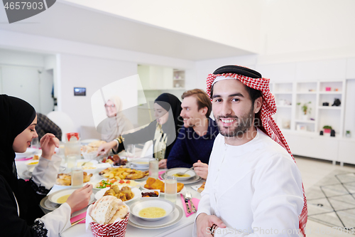 Image of young arabian man having Iftar dinner with muslim family