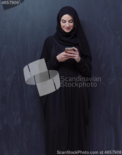 Image of young modern muslim business woman using smartphone