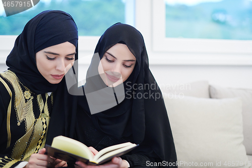 Image of young muslim women reading Quran at home