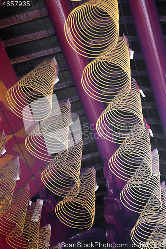 Image of Spiral incense burning hanging in Vietnamese temple