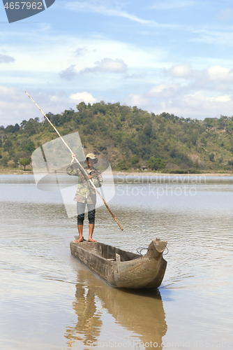 Image of Dak Lak, VIETNAM - JANUARY 6, 2015 - Man pushing a boat with a pole