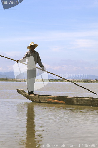 Image of Dak Lak, VIETNAM - JANUARY 6, 2015 - Man pushing a boat with a pole