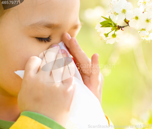 Image of Little girl is blowing her nose