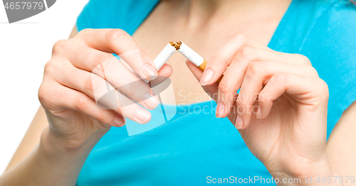 Image of Young woman is breaking a cigarette