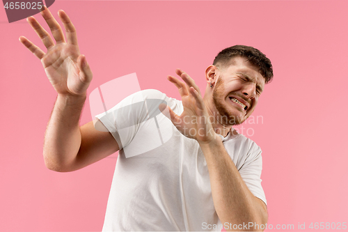 Image of Portrait of the scared man on pink