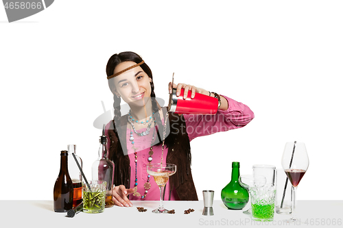 Image of Expert female barman is making cocktail at studio