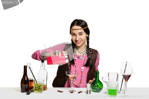 Image of Expert female barman is making cocktail at studio