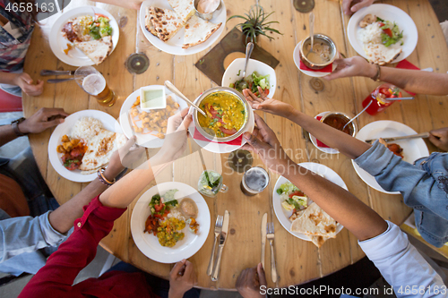 Image of international friends eating at restaurant